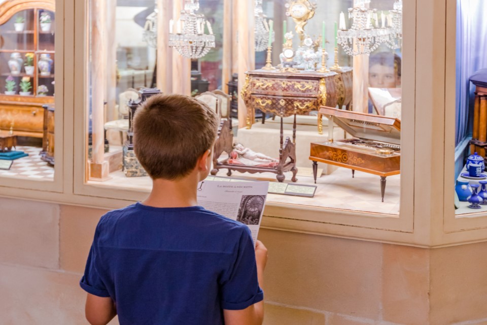 Un enfant observant une vitrine au château de Vendeuvre.