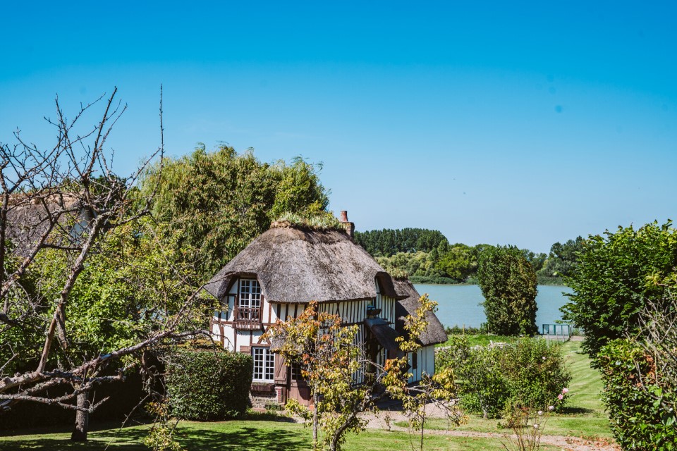 Une chaumière traditionnelle entourée de verdure en Normandie.