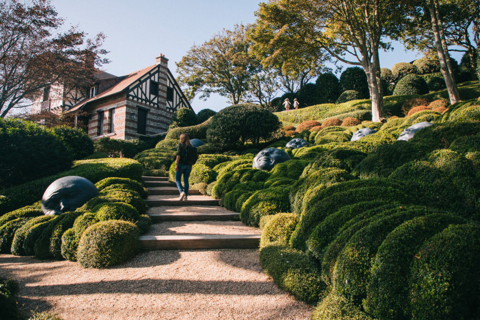 Paysage artistique des Jardins d'Étretat avec des sculptures et des buissons taillés.